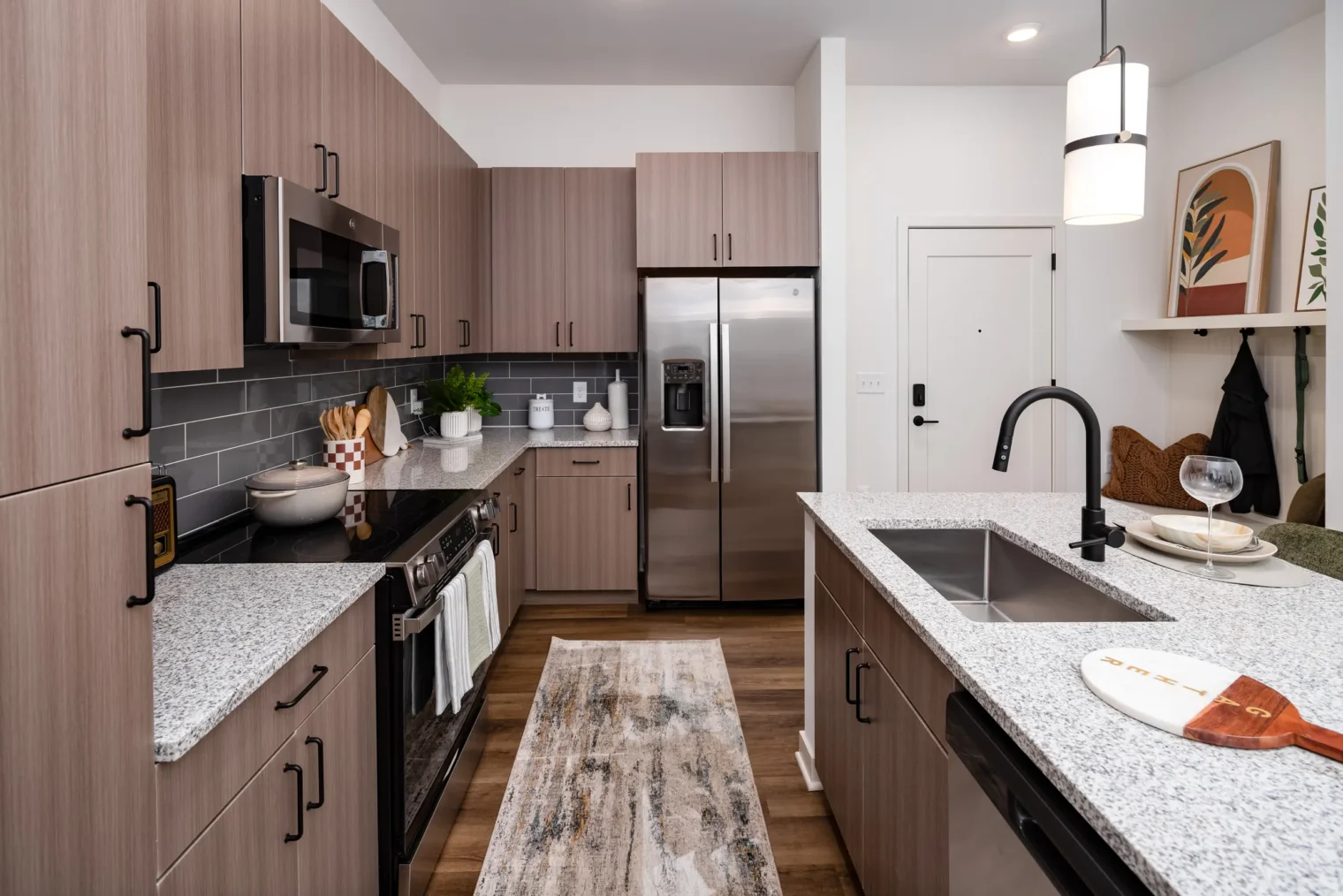Modern kitchen with granite countertops, wood cabinetry and stainless steel appliances at Everhill Kennesaw